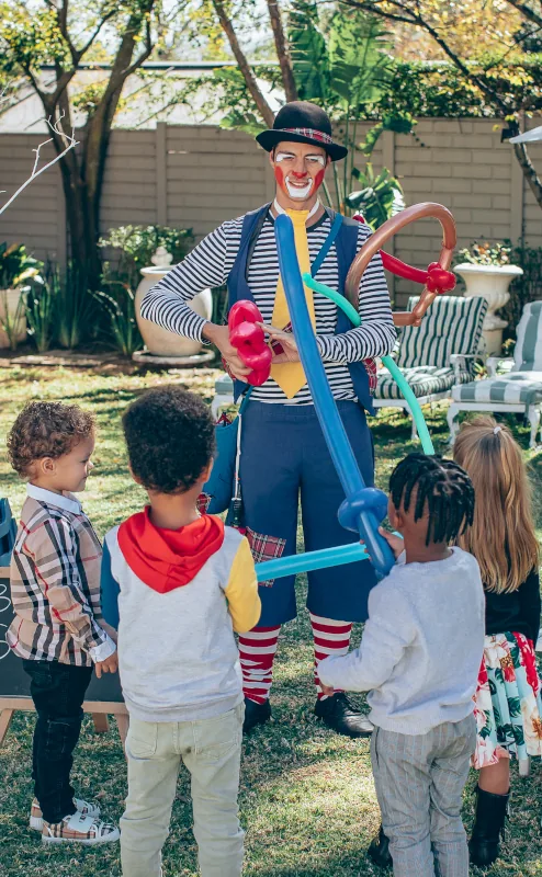 CJ the Clown making balloon sculptures for children at a garden party