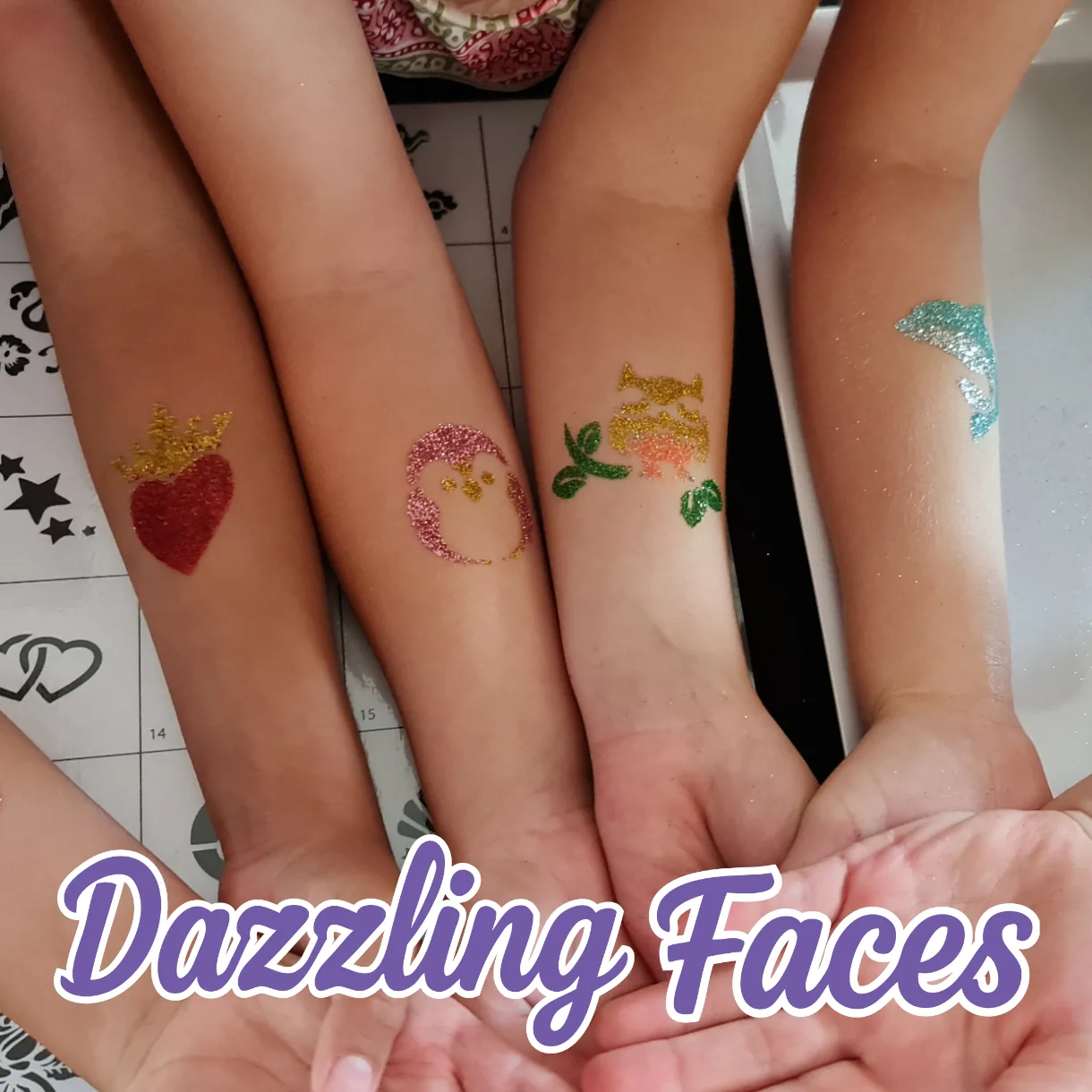 Four friends showing glitter tattoos: crowned heart, penguin, owl and dolphin